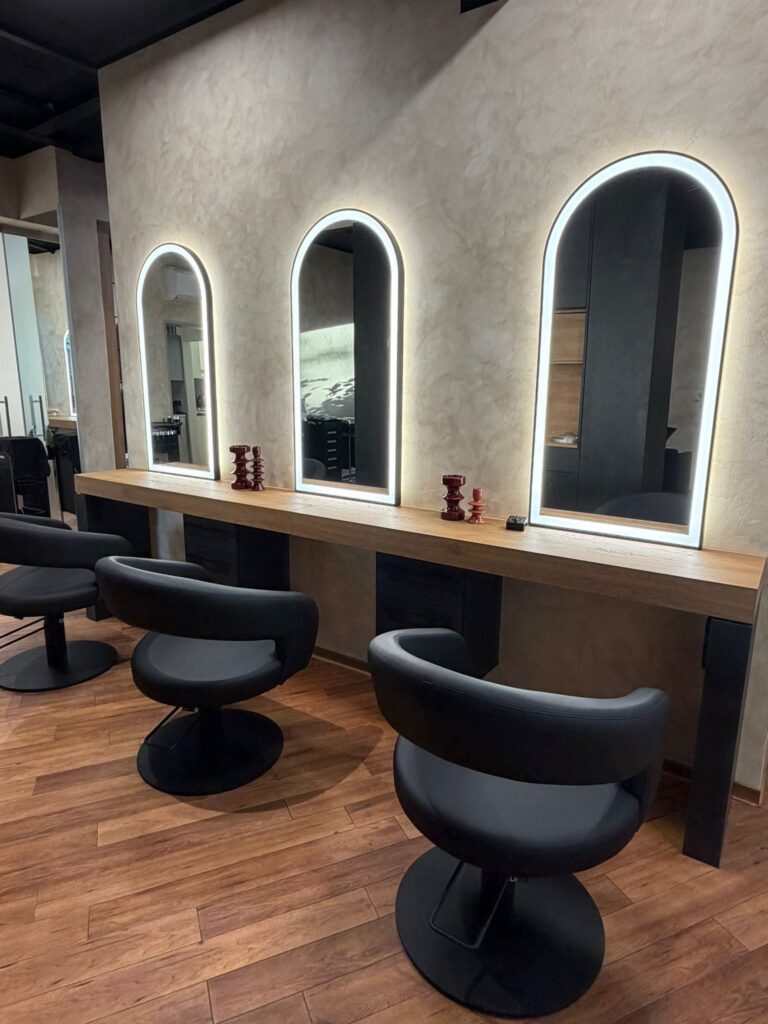 Beleuchtete Rundbogenspiegel an den Stylingplätzen bei Haar & Design Wahlbrink in Püsselbüren
